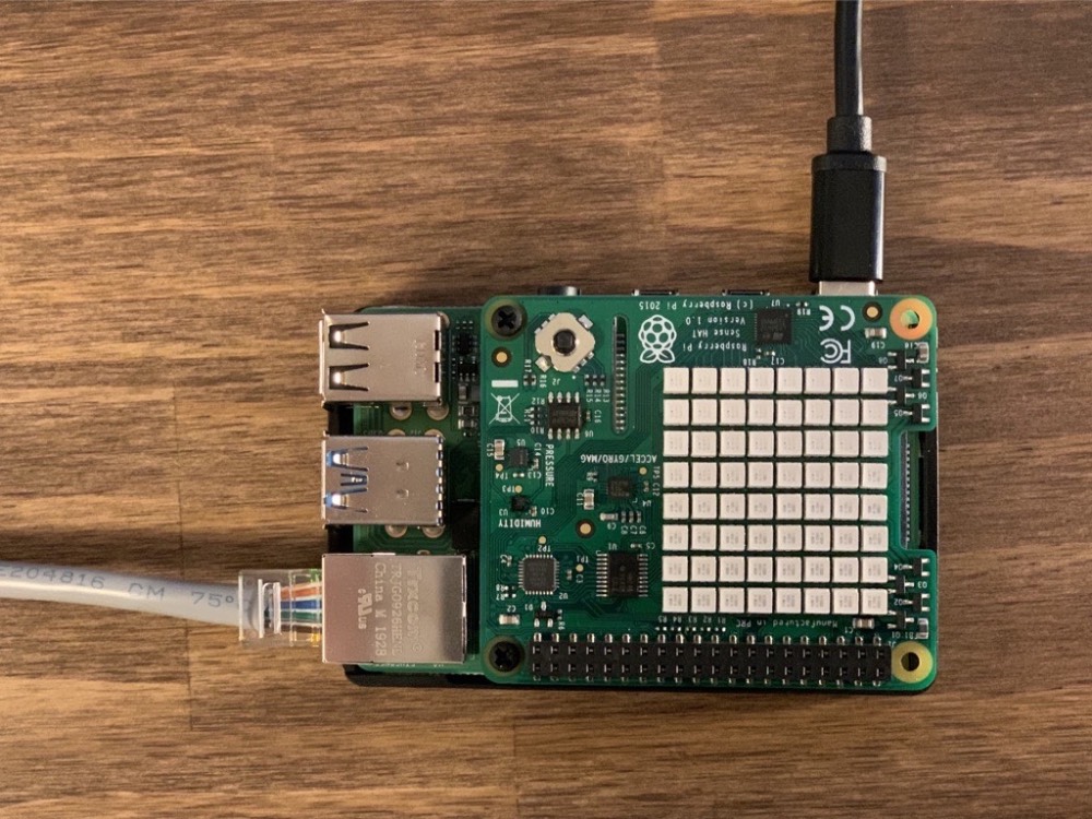 Raspberry Pi and Sense HAT assembled with power and ethernet